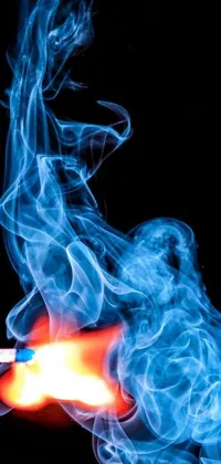 This live wallpaper features an eye-catching scene of blue smoke being ignited by a matchstick set against a black background with a red flame at its center