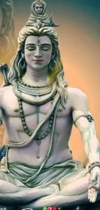 This breathtaking phone live wallpaper features a stunning statue of lord shiva seated in lotus position, set against a picturesque mountain landscape