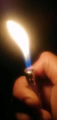 This striking phone live wallpaper features a mesmerizing scene of a lighter held in someone's hand, creating captivating blue flames