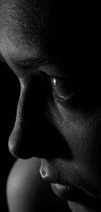 This live wallpaper features a high-quality black and white photograph of a man's face with dramatic, soft shadow lighting