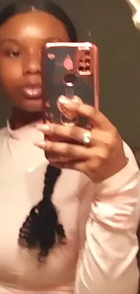This phone live wallpaper features a young woman taking a selfie in a mirror