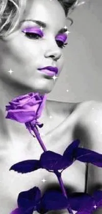 Looking for an elegant and artistic phone wallpaper? Look no further than this stunning black and white photo of a woman holding a beautiful purple rose