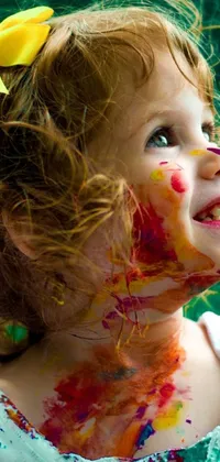 Add a touch of color and joy to your phone with this beautiful live wallpaper featuring a portrait of a young girl with paint all over her face