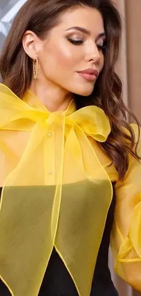 This stunning live wallpaper features a fashion-forward woman in a gorgeous yellow blouse and black pants
