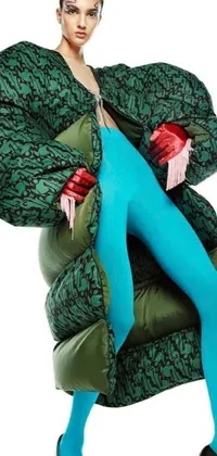 This lively live phone wallpaper depicts a woman in a green coat and blue tights, dressed in a puffer jacket and strikingly-patterned clothing
