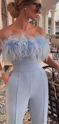 This live wallpaper features a stylish woman in a light-blue jumpsuit adorned with blue feathers