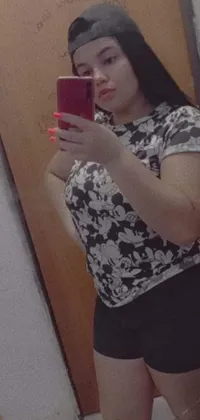 This stunning live wallpaper depicts a young Mexican woman taking a selfie in a mirror, captured perfectly by her smartphone