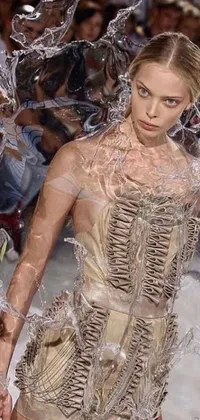 This live phone wallpaper features an avant-garde runway scene with a woman walking through water