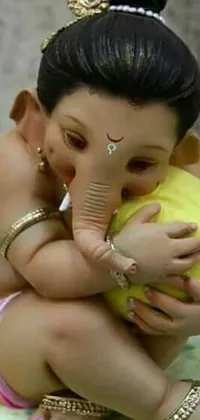 This cute and trendy live wallpaper features a small elephant statue holding a baby in its trunk