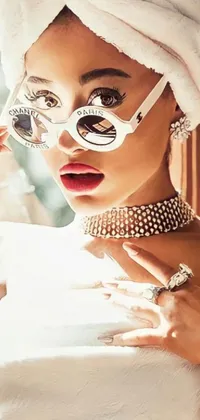 This phone live wallpaper showcases a stylish and glamorous woman with a towel wrapped around her head, chic round sunglasses and rapper-inspired bling jewelry