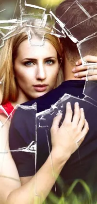 Enhance your phone with this heartwarming live wallpaper featuring a woman embracing a man from behind through a broken glass window