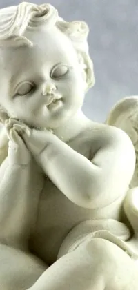 This live phone wallpaper showcases a close-up view of a marble statue of a bashful and sweet cherub angel