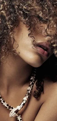 This phone live wallpaper features an exquisite close-up of a woman with curly hair wearing sensual gold and silver jewelry