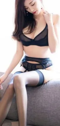 This phone live wallpaper features a close up half body shot of a woman in lingerie, sitting on a couch