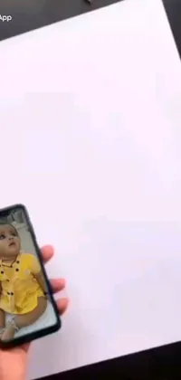 This phone live wallpaper showcases a beautiful moment of a baby being photographed with a cell phone
