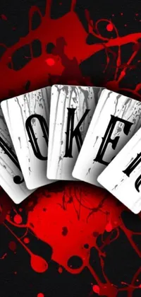 This captivating phone wallpaper features a bunch of playing cards on a wooden table, along with a striking gothic art joker with a sly smile
