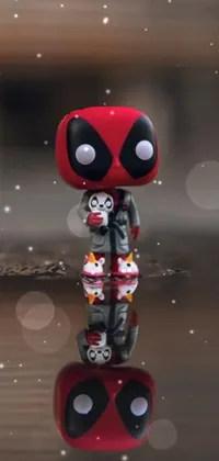 Spruce up your phone's background with this exciting live wallpaper featuring a Funko Pop deadpool figure resting atop a reflective water puddle