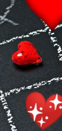 Are you in need of Valentine's Day wallpaper for your phone? Look no further than this adorable live wallpaper! Featuring a red heart sitting pretty on a chalkboard with vintage elements like glass bead clay amulets and a subtle animation effect, this wallpaper will add a charming and romantic touch to your screen