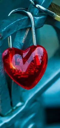 Get a one-of-a-kind phone live wallpaper with a red heart shaped padlock attached to a metal fence