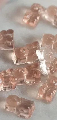 This live wallpaper features a shiny penny and colorful gummy bears on a light pink background