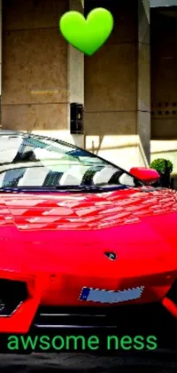 This phone live wallpaper features a striking image of a red sports car parked in front of a building, adorned with a green heart-shaped balloon on its roof