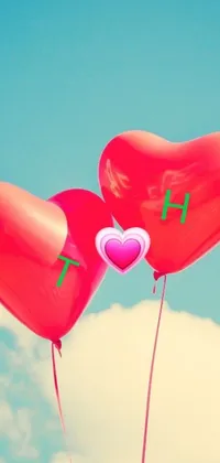 This live phone wallpaper features two heart-shaped balloons, a green and pink gradient background, clouds, and birds in the distance