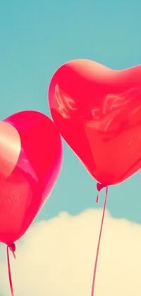 Looking for a romantic live wallpaper for your phone? Check out this charming design! Featuring two heart-shaped balloons in bright red, tied together with a ribbon, this wallpaper creates a lovely atmosphere on your phone's home screen