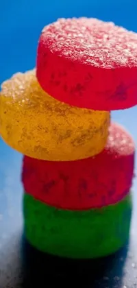 This live phone wallpaper features a colorful stack of gummy bears, captured in a macro photograph