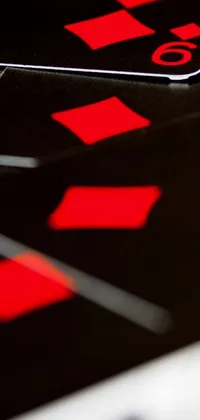 This mesmerizing live phone wallpaper showcases a close-up view of playing cards on a black table