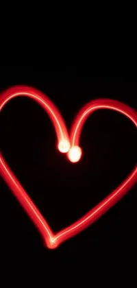 This heart shaped live wallpaper is a visually captivating piece that glows in the dark with a reddish-pink neon light