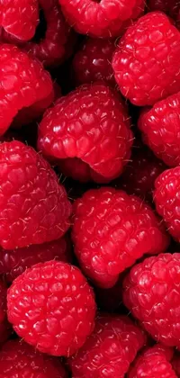 This phone wallpaper showcases a close-up photograph of raspberries with incredible detail and photorealism