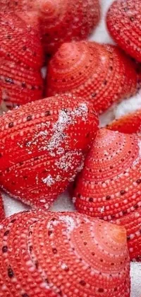 This live wallpaper features a stunning macro photograph of a pile of ripe strawberries resting on a wooden table