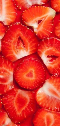This live phone wallpaper features a stunning macro photograph of fresh sliced strawberries lined up in an attractive pattern