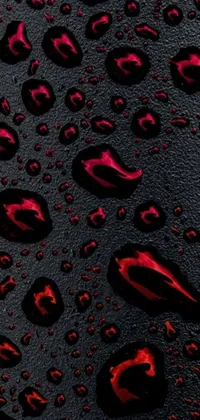 This phone live wallpaper features a close-up view of water droplets on a black surface, creating a mesmerizing texture that shifts with your phone's movement