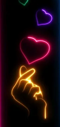 This stunning phone live wallpaper features a close-up shot of a neon heart being touched by a hand with a finger placed on it