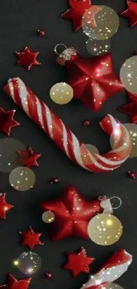 This dynamic phone live wallpaper is sure to impress! It features a close-up of a vibrant candy cane atop a table, surrounded by a stunning galaxy of multicolored, glowing wax and ceramic ornaments and twinkling stars