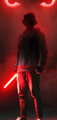 Looking for a striking live wallpaper for your mobile device? Look no further than this incredible piece of digital art! This HD wallpaper features a teenage boy in a red hoodie standing before a menacing red lightsaber, set against a backdrop of epic Star Wars imagery