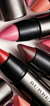This phone live wallpaper features a beautiful arrangement of photorealistic lipsticks in a mix of Burberry-inspired pink and red hues