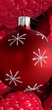 This stunning live wallpaper features a vibrant red ornament resting on a pile of luscious raspberries, intricate snowflakes, abstract mandelblub fractal, and festive ornamental decorations, all set against a gradient blue background