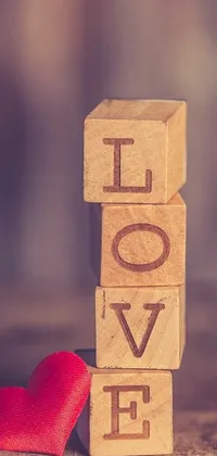 This phone live wallpaper showcases a wooden block with the word "love" next to a red heart