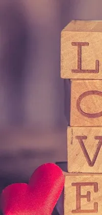 This mobile live wallpaper features a charming wooden block with the word "love" written in white letters and a small red heart next to it