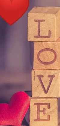 This vertical phone live wallpaper features simple wooden blocks nestled next to a stunning red heart on a cubist-inspired backdrop