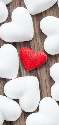 Get ready to add a touch of romance to your phone's background with this stunning wallpaper! This live wallpaper features a beautiful red heart in the center, surrounded by fluffy white marshmallows, all set against a natural wooden table background