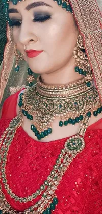 This live wallpaper depicts a close-up of a woman wearing a red dress adorned with intricate green jewelry and a gold choker
