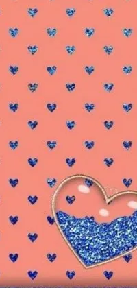 This phone live wallpaper features a stunning blue glitter heart with crystal accents set against a soft pink background