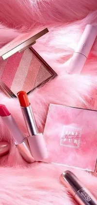 This phone live wallpaper depicts an aesthetically pleasing image of cosmetics placed on a fluffy pink fur