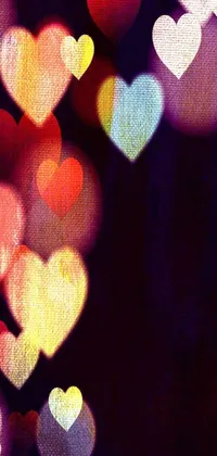 Enhance your phone's screen with this trendy live wallpaper featuring a beautiful array of pointillism style hearts floating in the air against softly dimmed lights