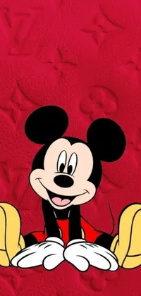 This lively phone wallpaper showcases the beloved cartoon character Mickey Mouse as he sits upon a bright red background surrounded by vivid digital art