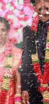 This phone live wallpaper depicts a man and woman standing side by side, the woman being an Indian girl with brown skin and a pretty bouquet in her hands