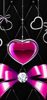 This phone live wallpaper showcases a pink heart with a bow on a black background encrusted with sparkling gems
